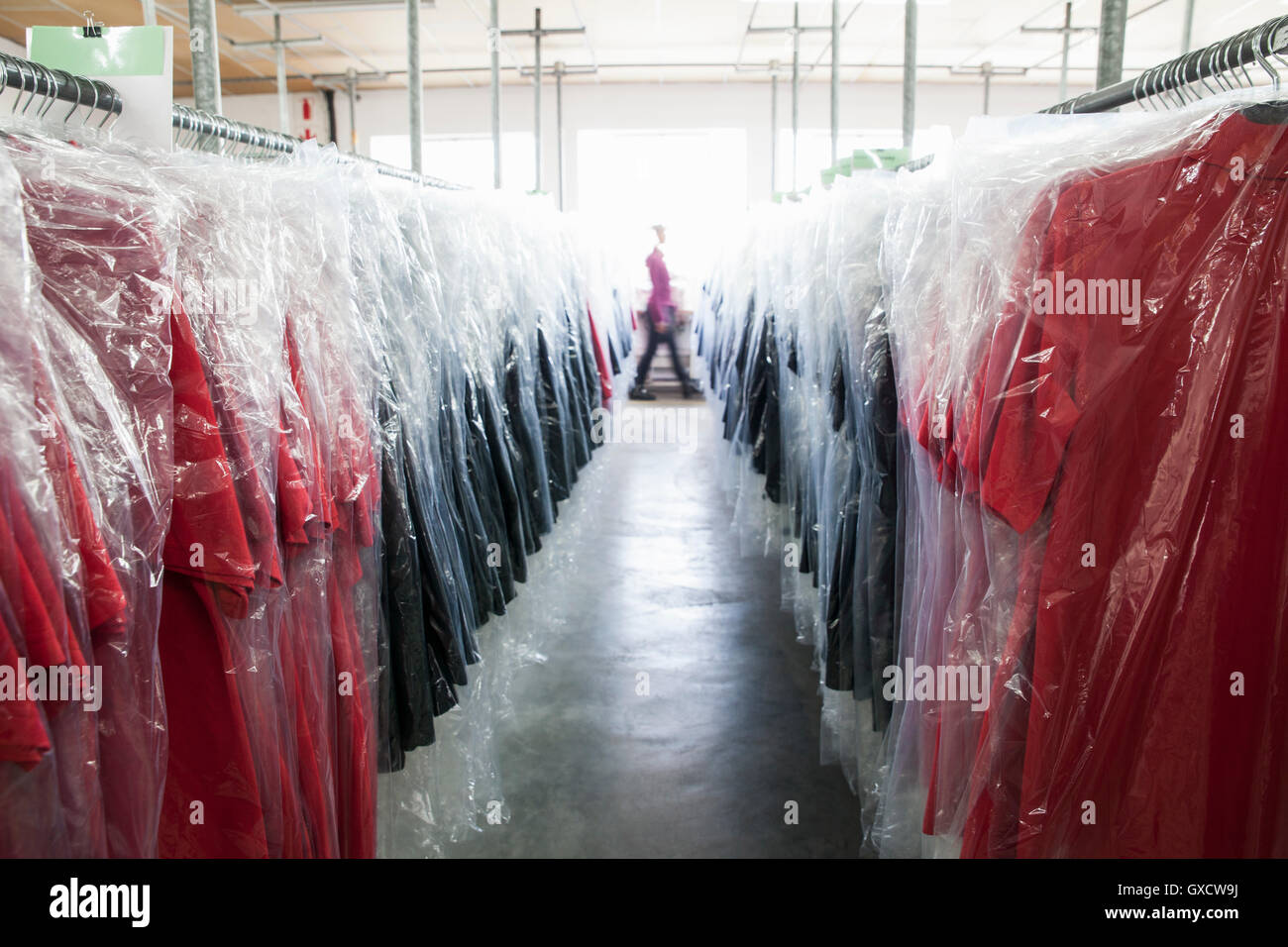 Abnehmende Perspektive von Kleidungsstücken auf Kleiderstange im Bekleidungswerk Stockfoto