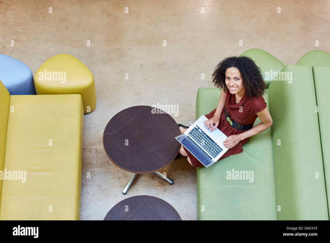 Obenliegende Porträt der Geschäftsfrau mit Laptop auf Design Studio sofa Stockfoto