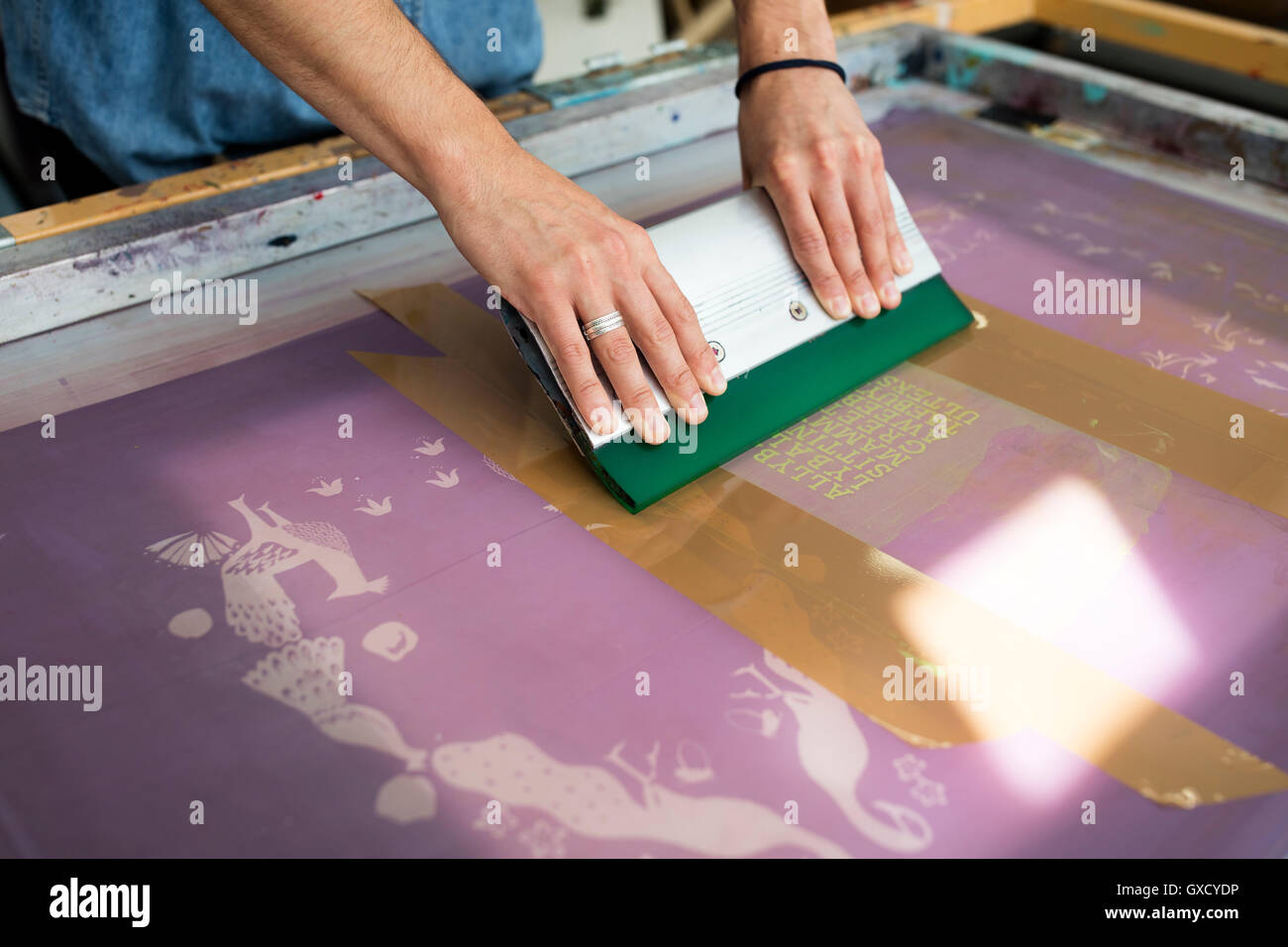 Hände der jungen männlichen Drucker mit Rakel in Druckmaschine studio Stockfoto
