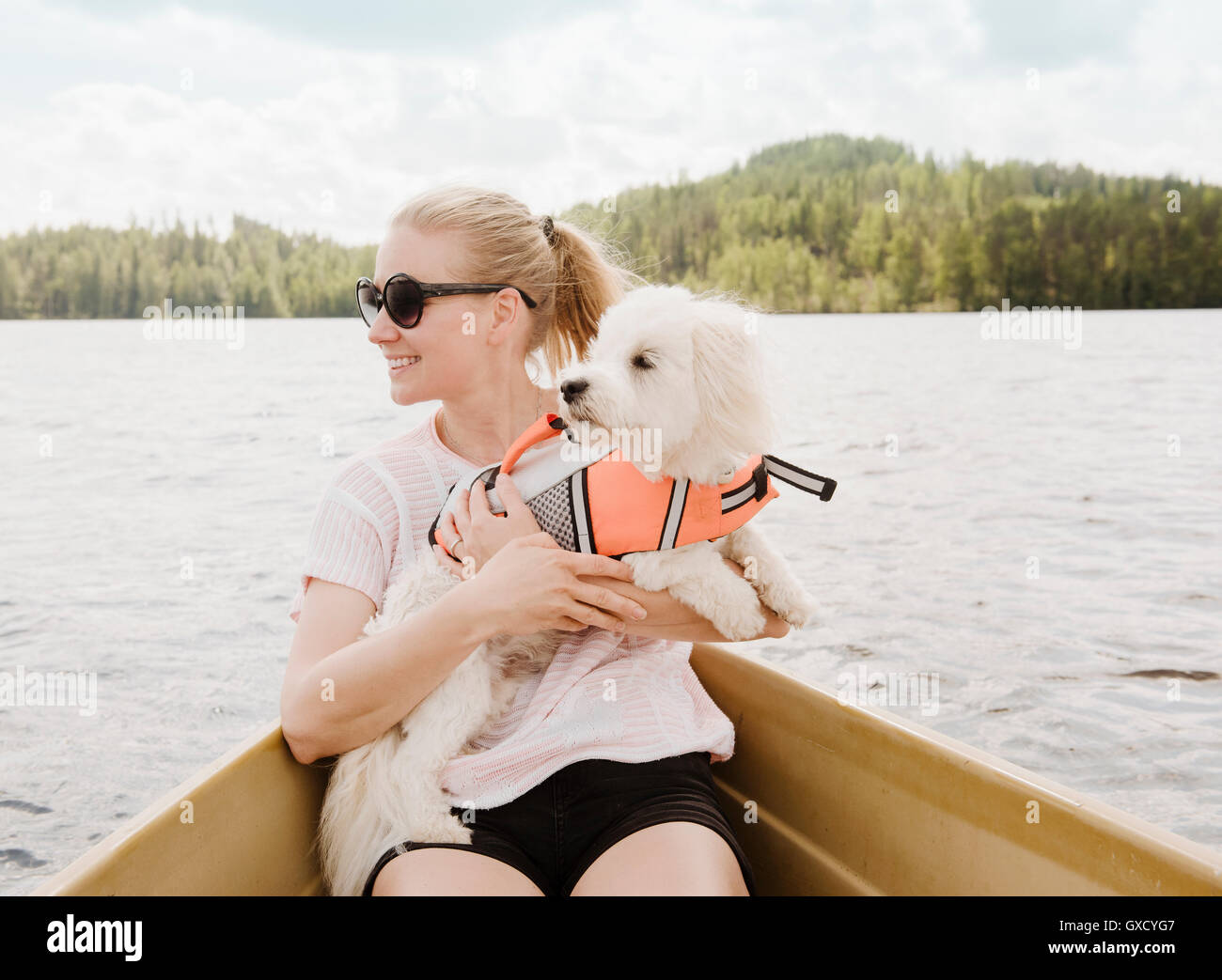 Frau mit Coton de Tulear Hund im Boot, Orivesi, Finnland Stockfoto