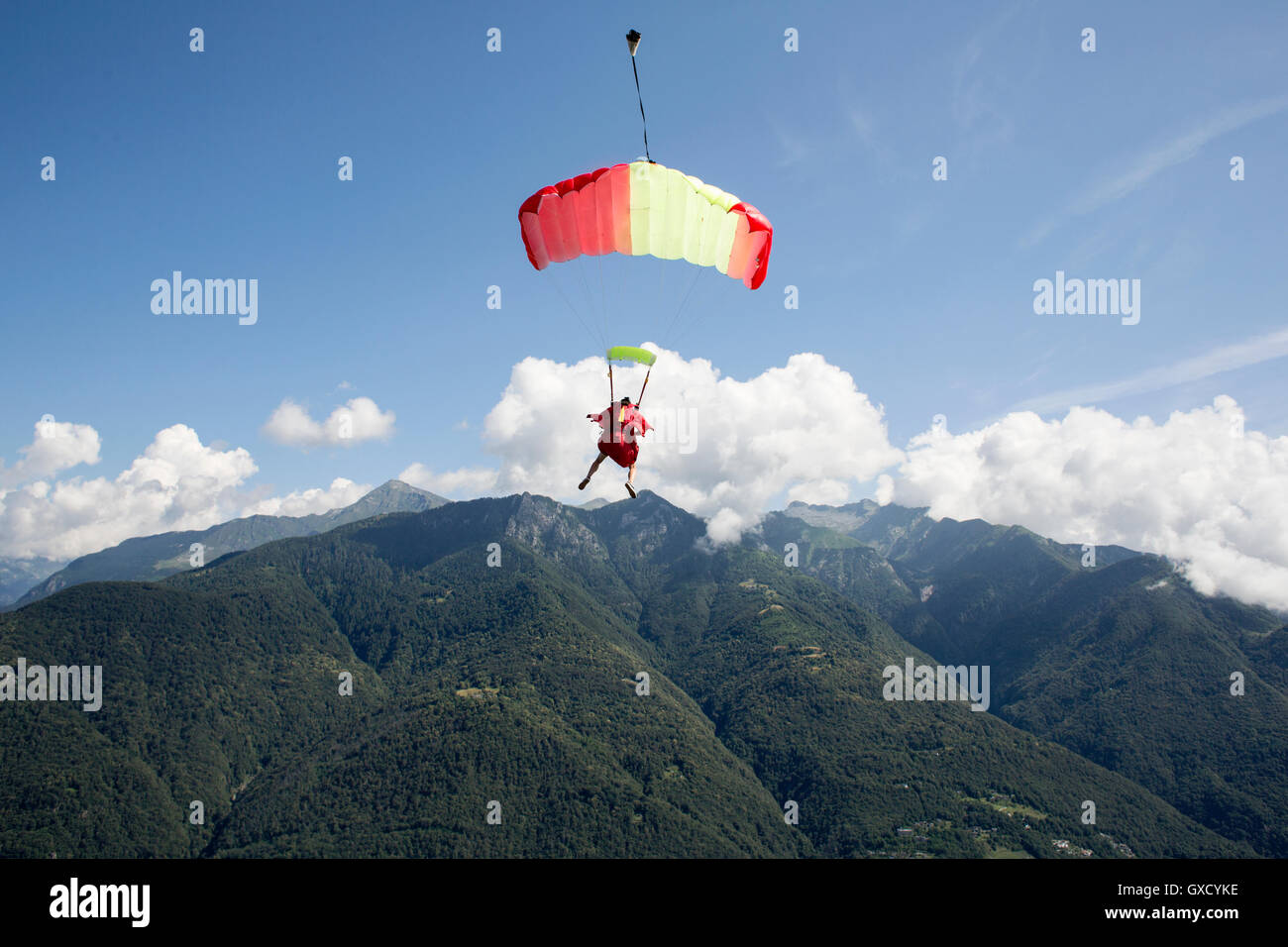 Fallschirmspringer unter ihrem Fallschirm fliegen kostenlos in den blauen Himmel, Locarno, Tessin, Schweiz Stockfoto