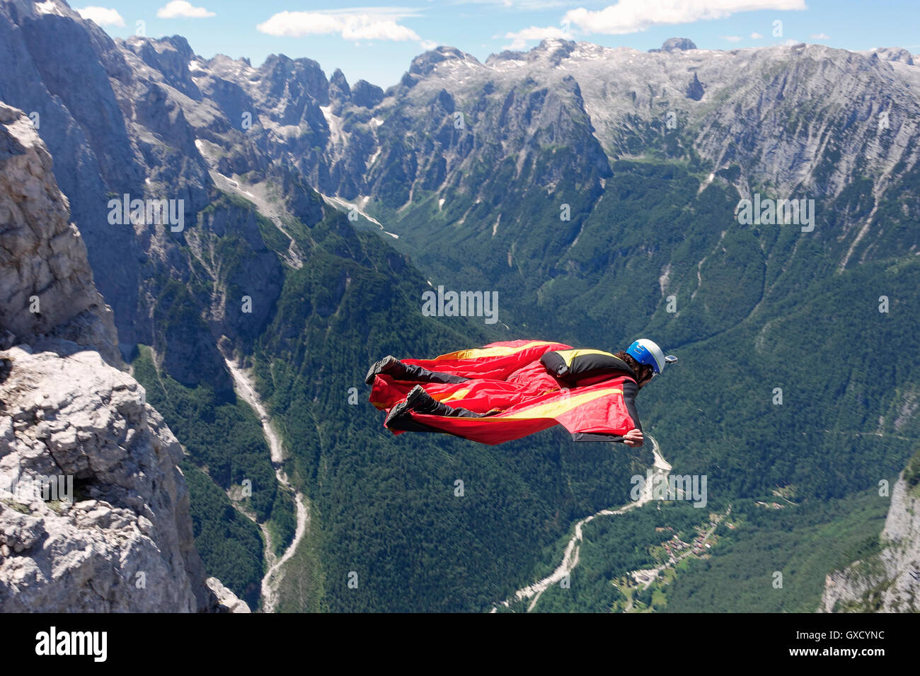 Wingsuit BASE-Jumper fliegen entlang der Klippen und hinunter ins Tal, Italienische Alpen, Alleghe, Belluno, Italien Stockfoto
