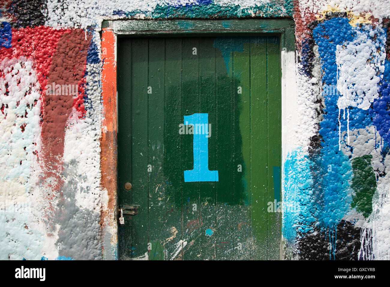 Nummer 1 Tür und Farbe bedeckte Wand in Werft Maler Stockfoto