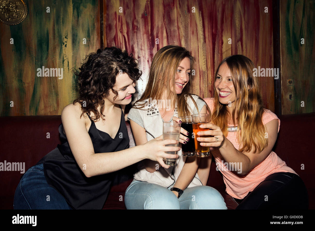 Drei Erwachsene Freundinnen ein Glas zu heben, sitzen in der Bar Stockfoto