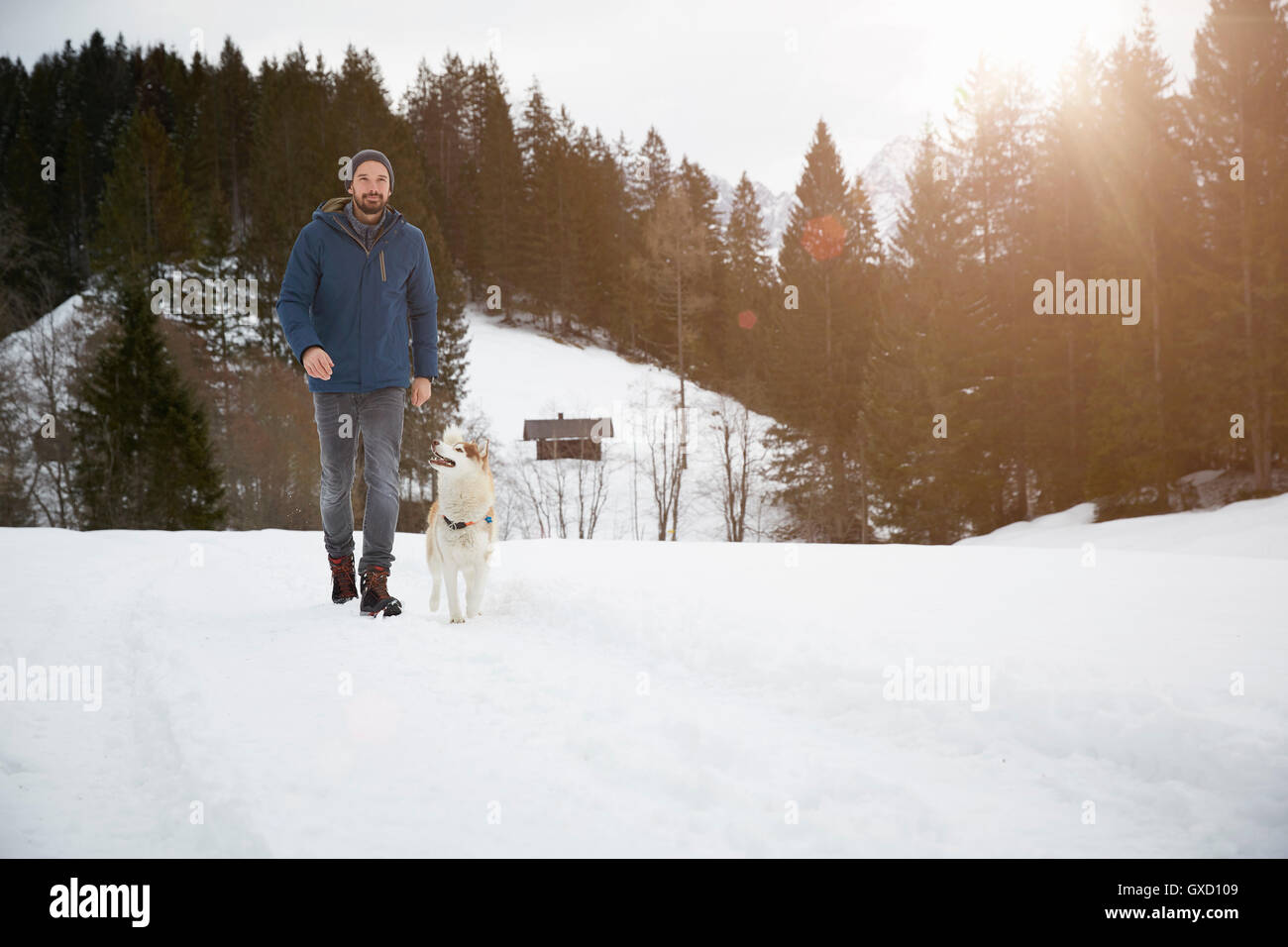 Mann zu Fuß Hund auf verschneite Landschaft, Elmau, Bayern, Deutschland Stockfoto