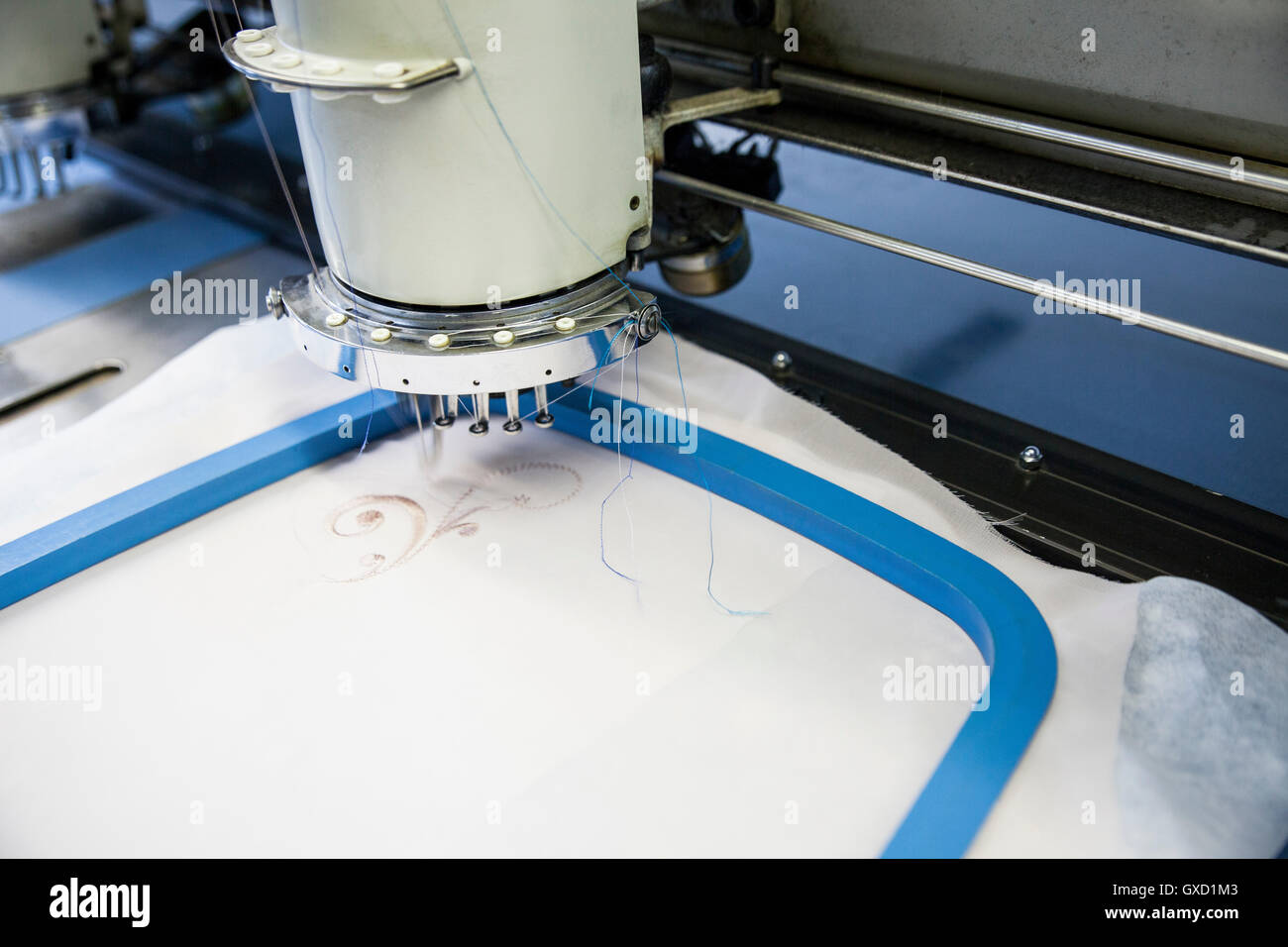Nahaufnahme von programmierten Stickgeschwindigkeit Maschine Nähen Stoff in Kleiderfabrik Stockfoto