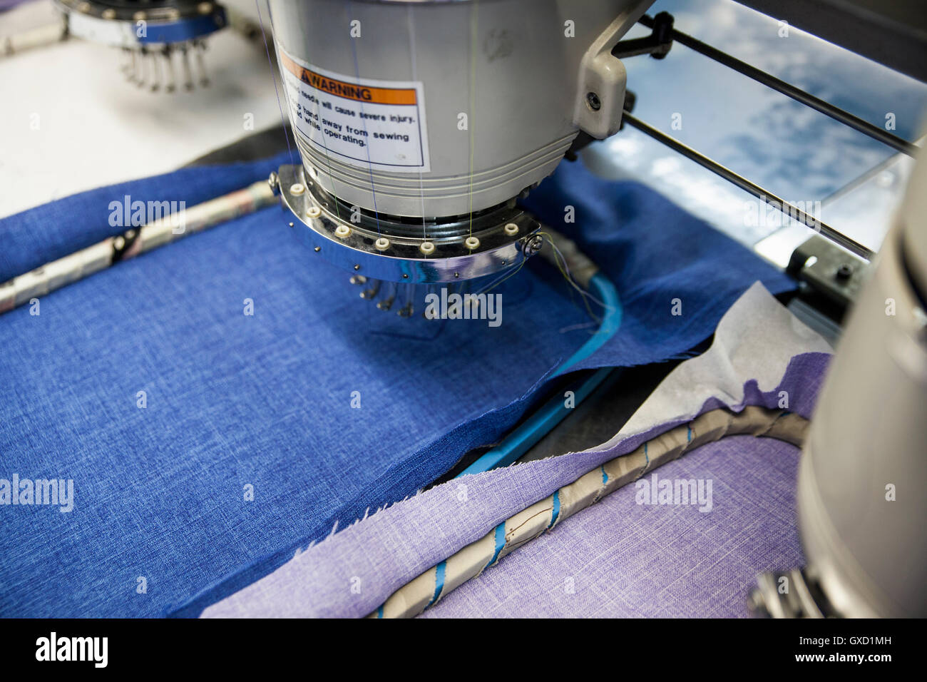 Programmierten Maschinen Stickgeschwindigkeit Nähte blau und lila Tuch in Kleiderfabrik Stockfoto
