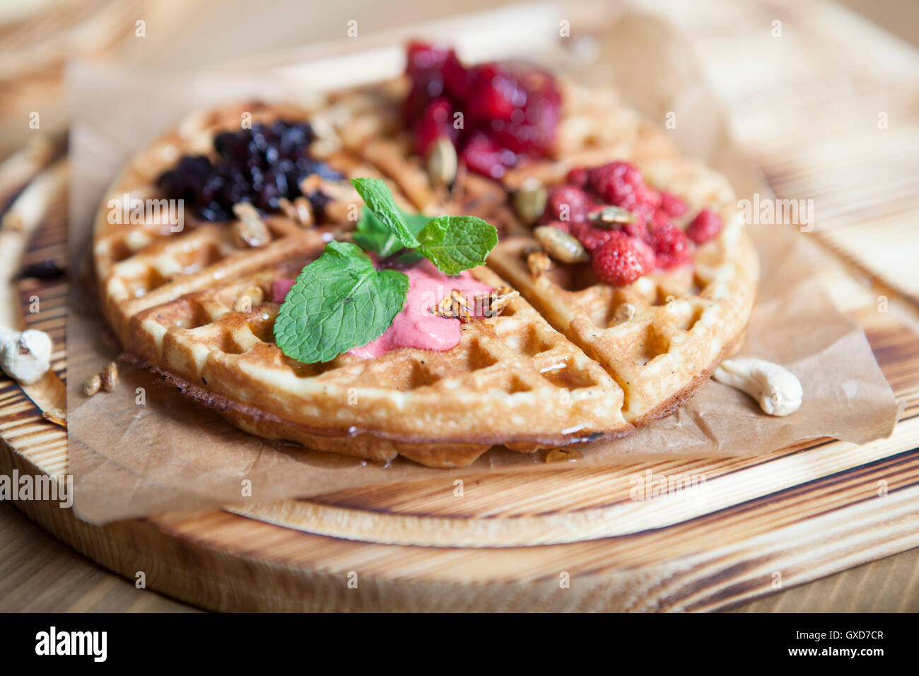 Teller mit belgischen Waffeln mit Eis, Sauce und frischen Beeren Stockfoto