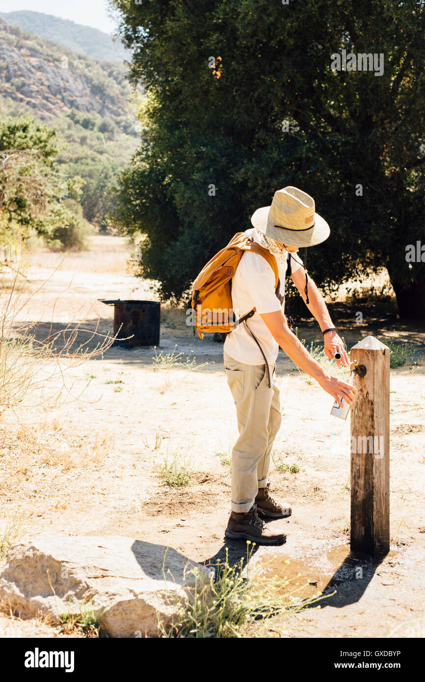Mann Füllung Wasserflasche an Outdoor-Armatur, Malibu Canyon, Kalifornien, USA Stockfoto