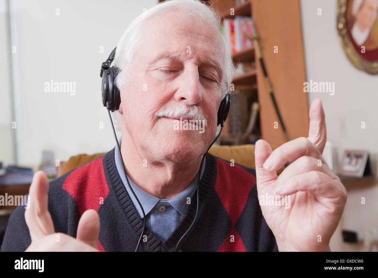 Senior woman anhören von Musik über Kopfhörer zu Hause Stockfoto