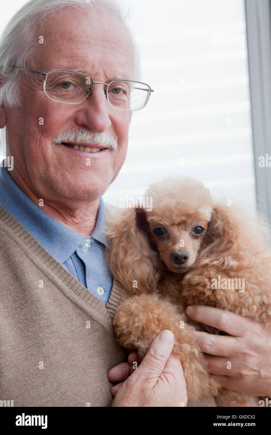 Ältere Mann mit Hund zu Hause Stockfoto