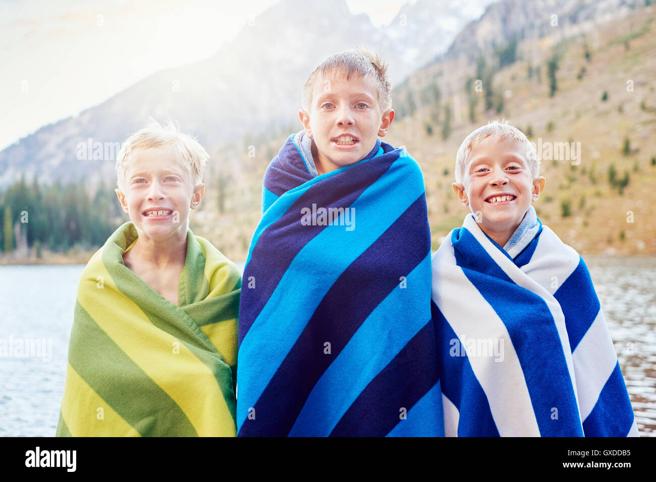 Porträt von männlichen Zwillingen und Bruder eingewickelt in Decken, Zittern, Grand-Teton-Nationalpark, Wyoming, USA Stockfoto