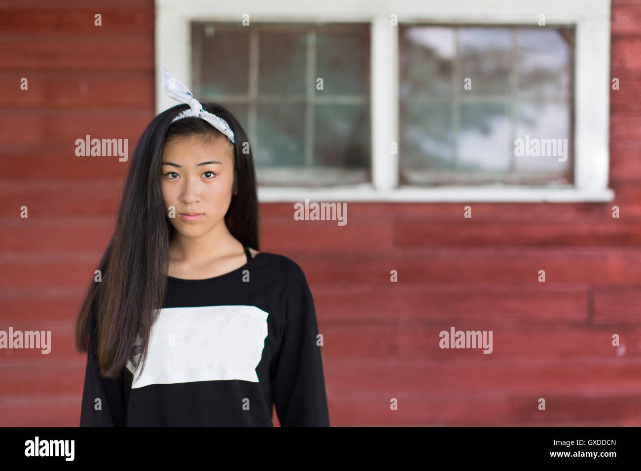 Porträt von Teenager-Mädchen mit langen schwarzen Haaren und Haarband in Veranda Stockfoto