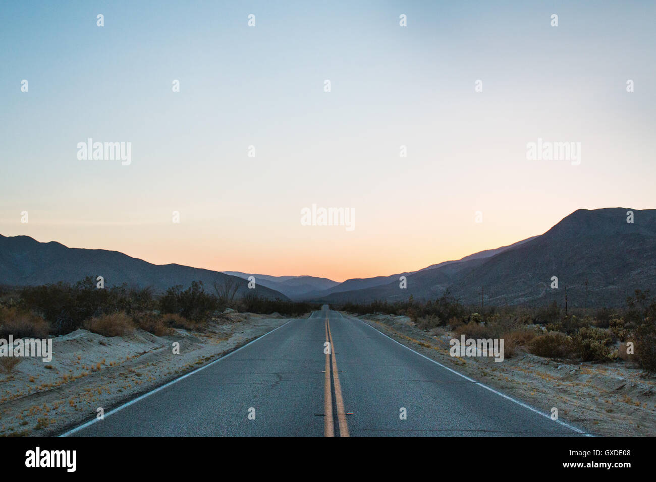 Landstraße in Berge bei Sonnenuntergang, Anza Borrego, Kalifornien, USA Stockfoto