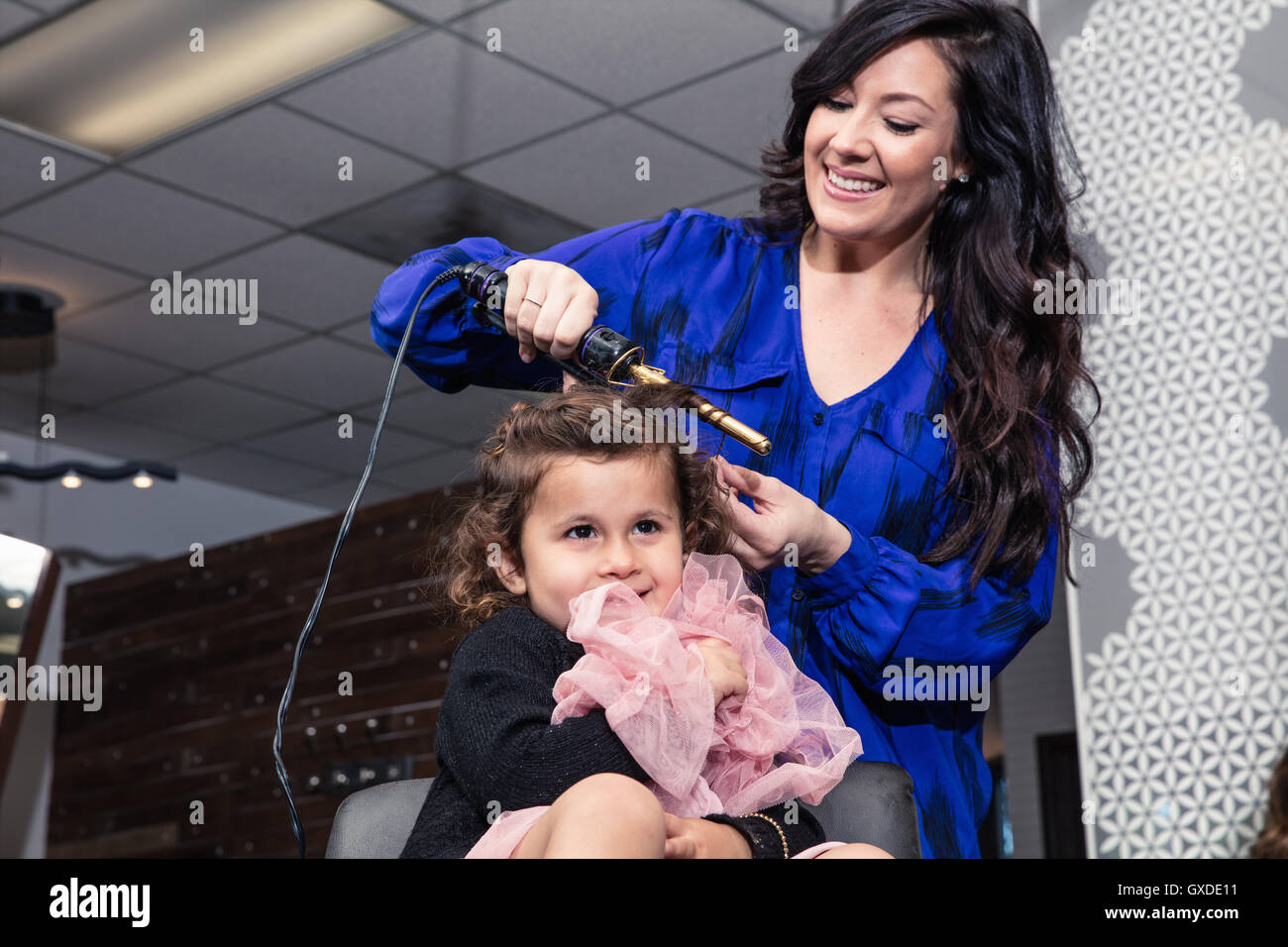 Stylist curling Mädchens Haare im salon Stockfoto