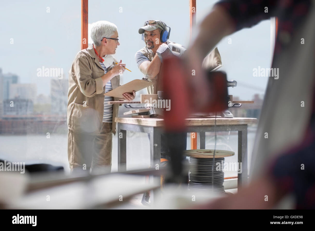 Tischler mit Diskussion in Werkstatt, Möbelbau Stockfoto