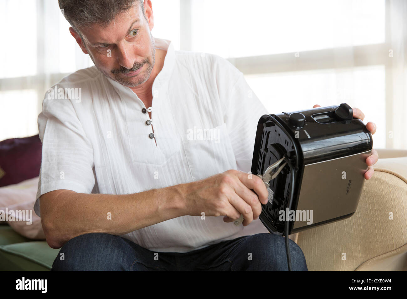 Mann mittlerer Alter ist einen Toaster zur Festsetzung Stockfoto