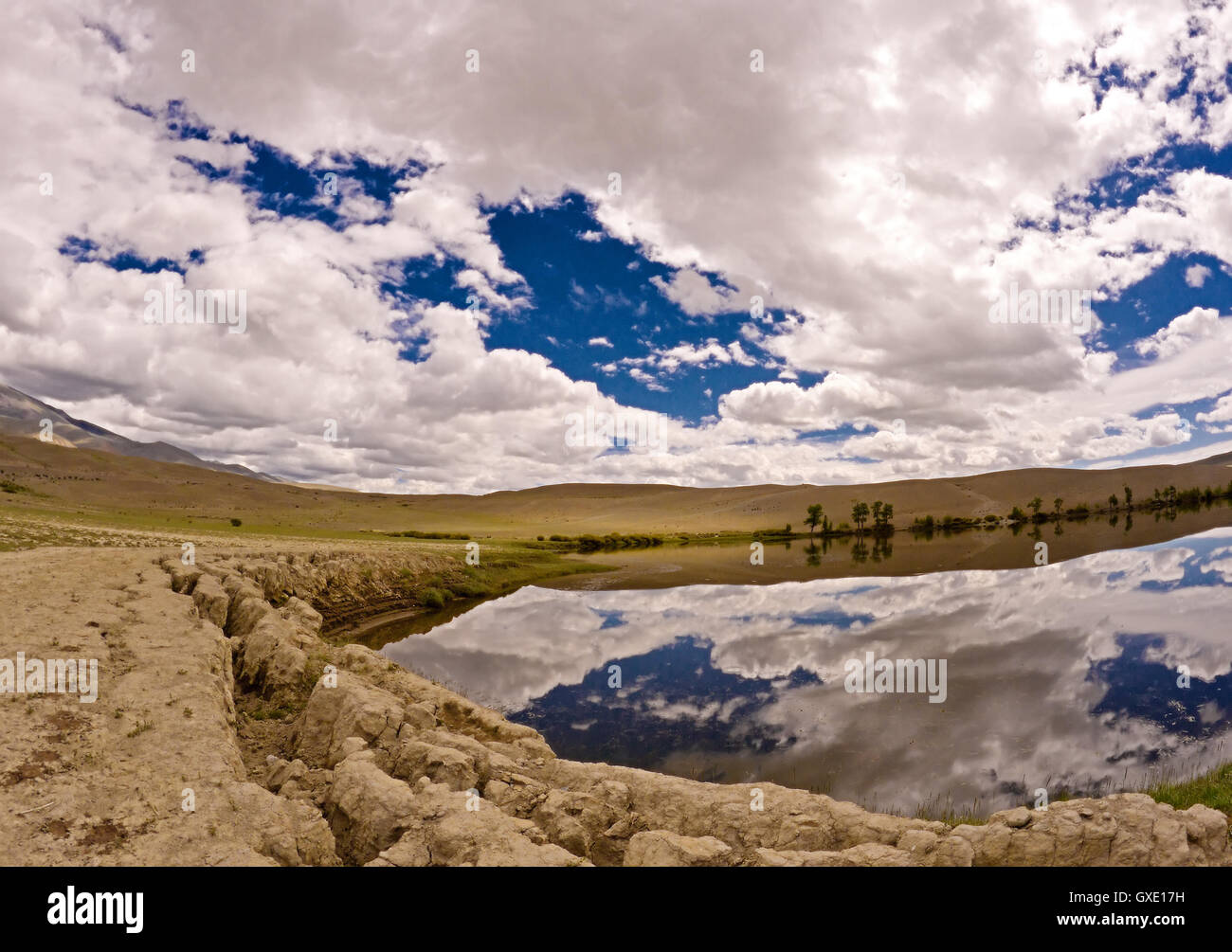 Steppe halb Wüstenlandschaft des Altai-Gebirges (Russland): trockene Ton-Lehm-Erde mit seltenen Pflanzen und ein See mit Himmel Reflexion Stockfoto