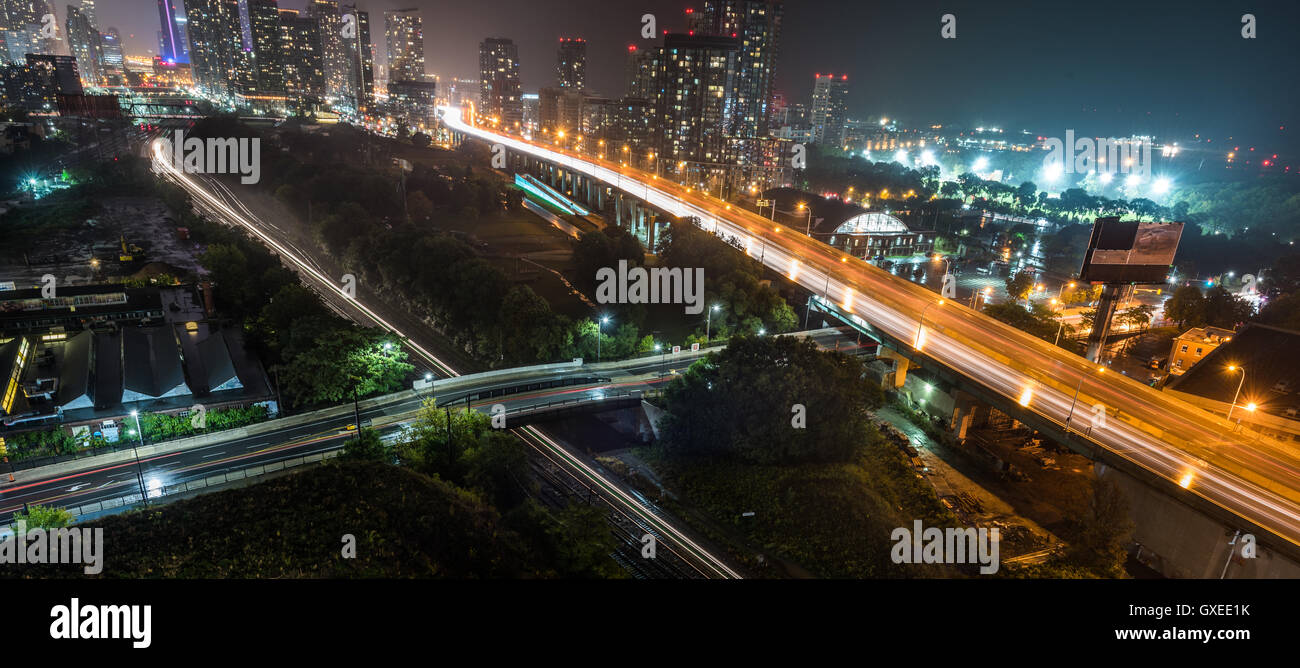 Glow helle Streifen von u-Bahn Zug neben Gardiner Expressway in einer heißen & schwülen Sommernacht in Toronto, Kanada am See. Stockfoto