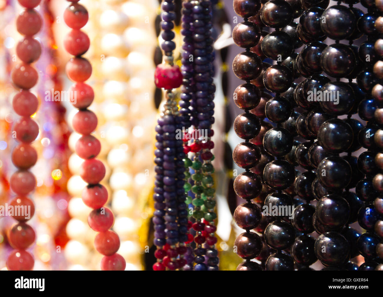 Bunte (bunte) handgemachte Accessoires (Halsketten, Perlen) aus Edelsteinen auf der Shopboard für den Verkauf vorbereitet Stockfoto