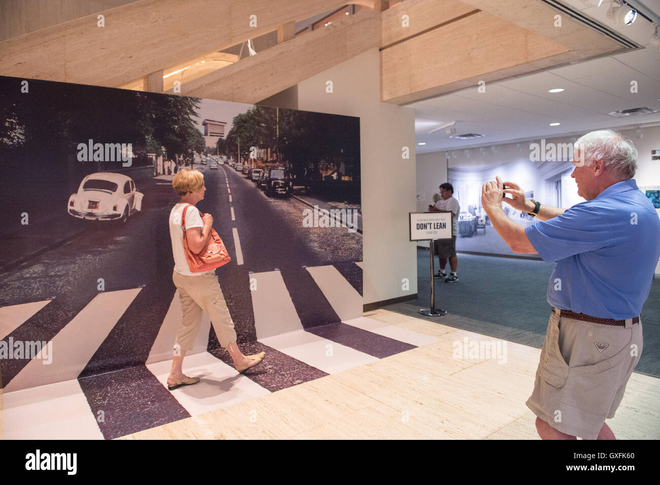 Eine Frau steht vor einem Foto Wandbild und bekommt ihr Foto zu Fuß über Abbey Road. Die Anzeige ist Teil einer temporären Beatles Ausstellung im LBJ Presidential Library 12. Juni 2015 in Austin, Texas. Diese Reisenden Ausstellung präsentiert seltene amerikanische Pop-Kultur und Musik Erinnerungsstücke. Stockfoto