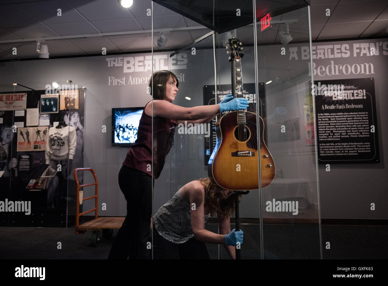 Mitarbeiter des Museums installieren sorgfältig John Lennons verschollenen 1962 Gibson J-160E Akustikgitarre, auf dem Display für zwei Wochen während einer Reisen Beatles Ausstellung auf der LBJ Presidential Library 10. Juni 2015 in Austin, Texas. Die fehlende Gitarre wurde im Jahr 2008 entdeckt, nach 50 Jahren verloren. Stockfoto