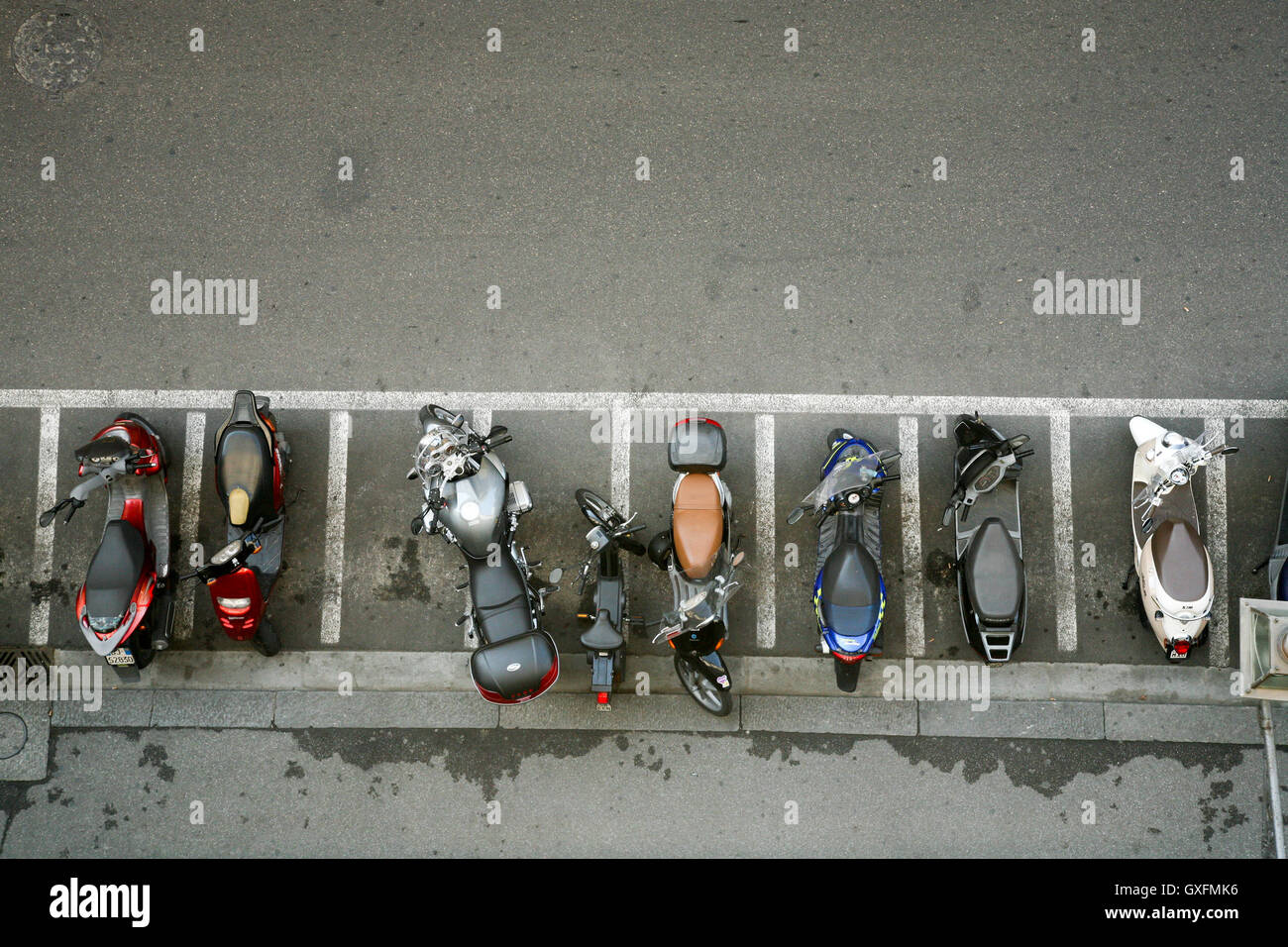 Blick nach unten der Spitzen der Motorräder in Parklücken aufgereiht. in den Straßen von Florenz, Italien. Stockfoto
