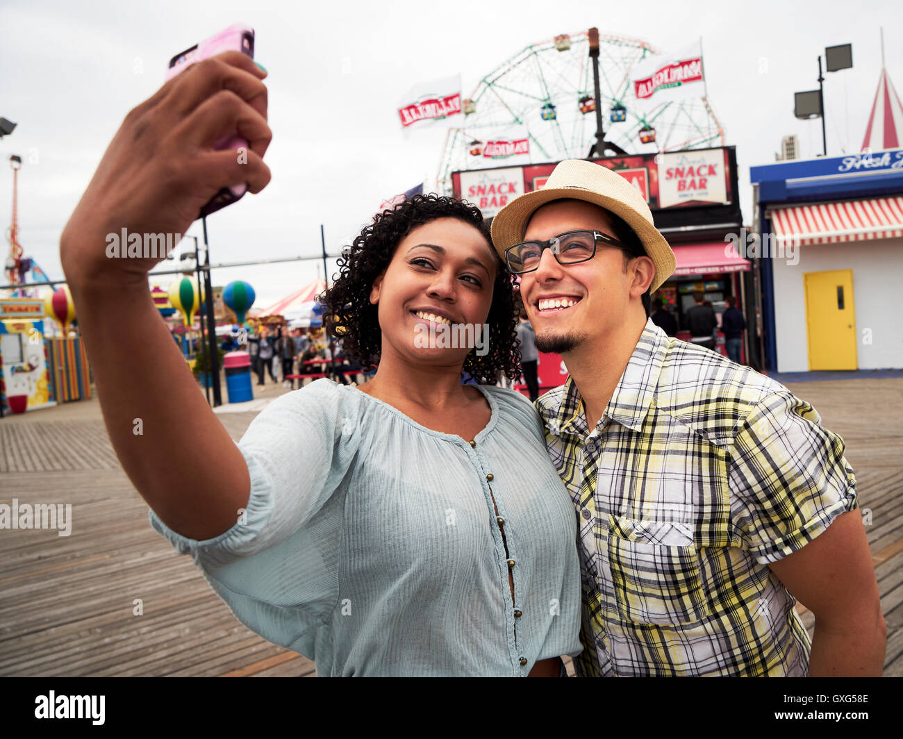 Paar posieren für Selfie auf Promenade im Freizeitpark Stockfoto