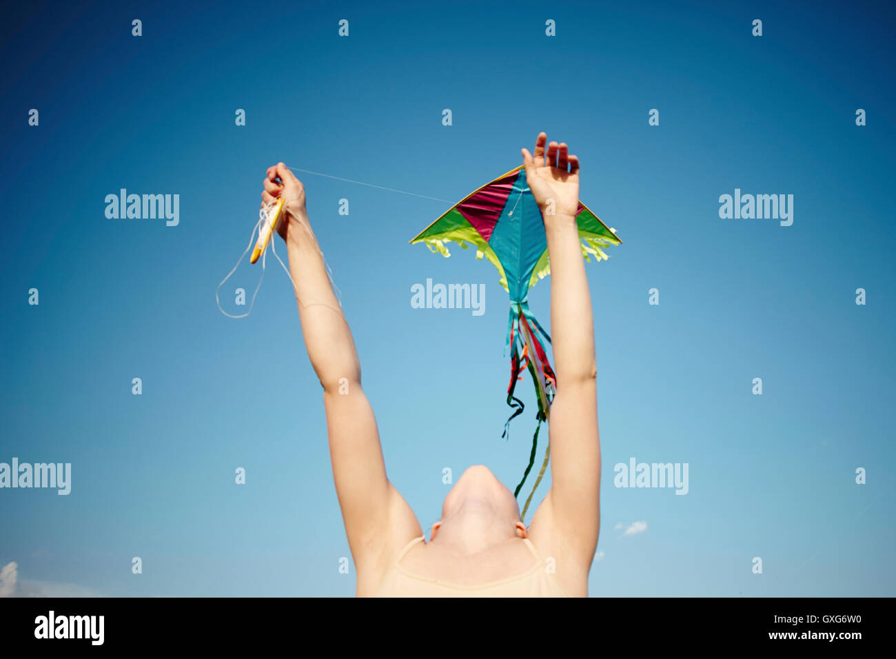 Kaukasische Mädchen mit Armen angehoben Drachen Stockfoto