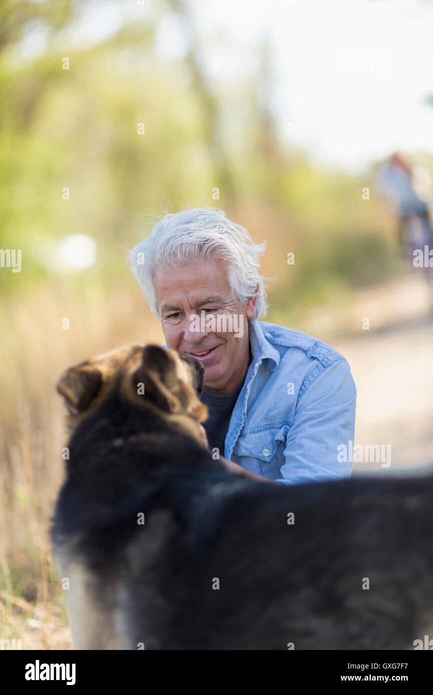 Kaukasischen Mann Petting Hund Feldweg Stockfoto