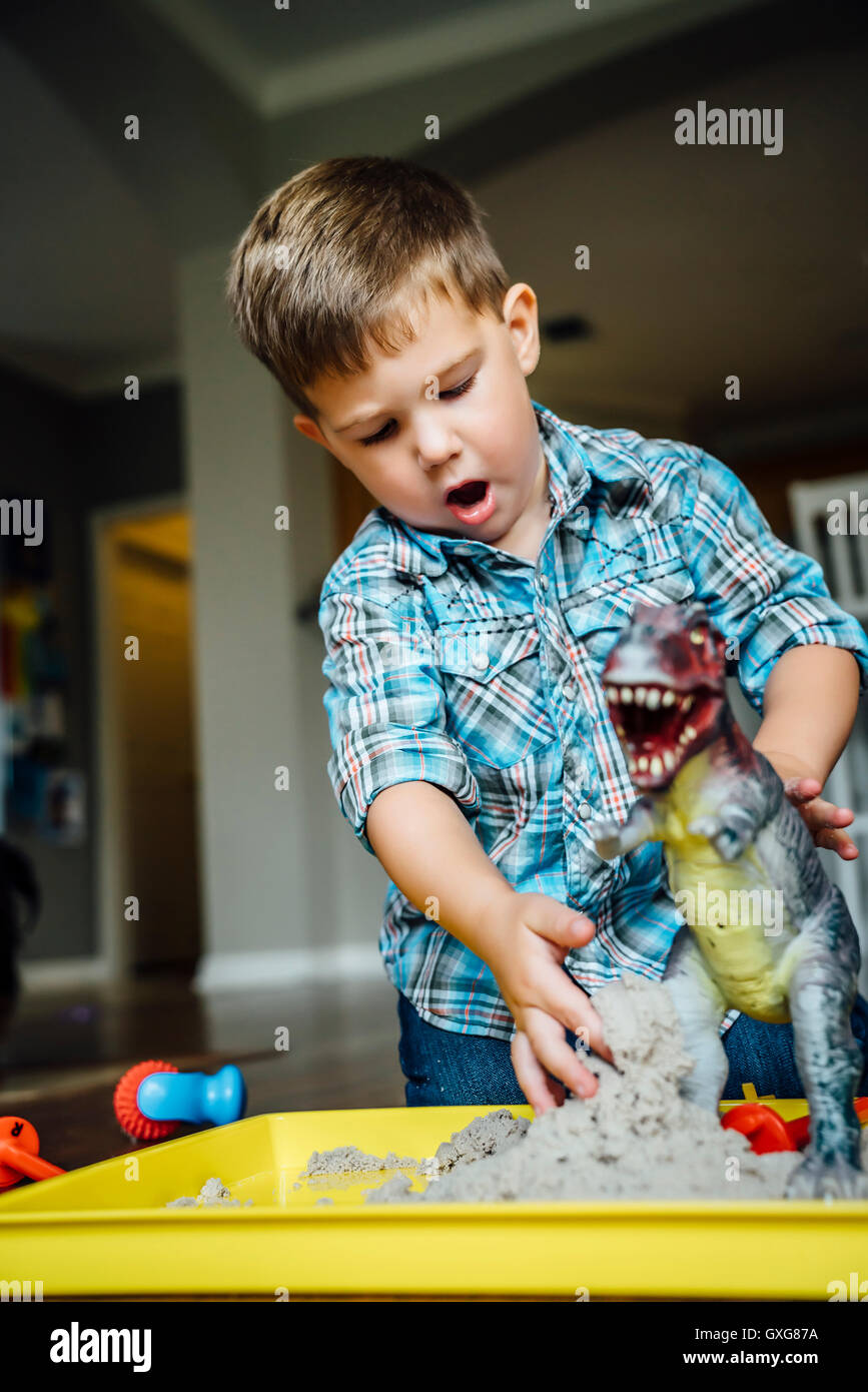 Kaukasische junge spielt mit Spielzeug Dinosaurier Stockfoto