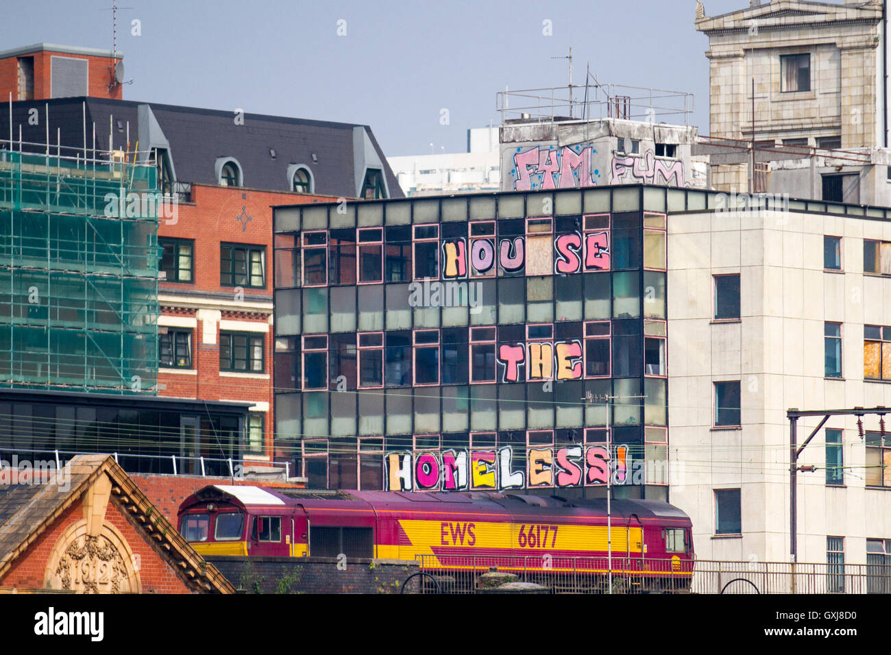 Haus der Obdachlosen. Schriftzug in Windows belegten Gebäude platziert. Die Skyline von gewerblichen Gebäuden in Manchester, Großbritannien Stockfoto