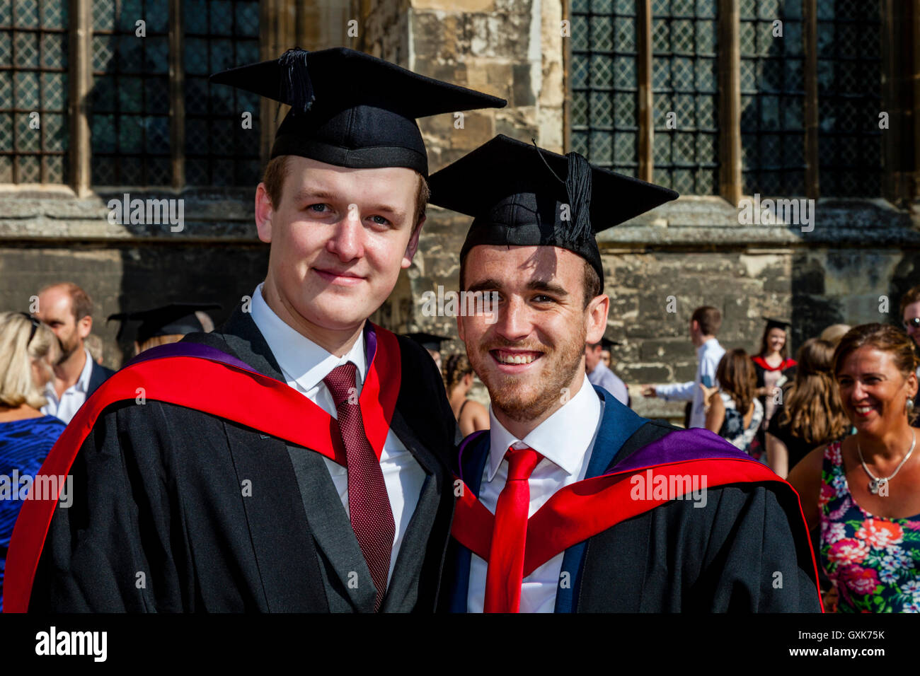 Zwei Hochschulabsolventen posieren für ein Foto vor Canterbury Kathedrale vor ihrer Graduierung Zeremonie, Canterbury, Kent, UK Stockfoto