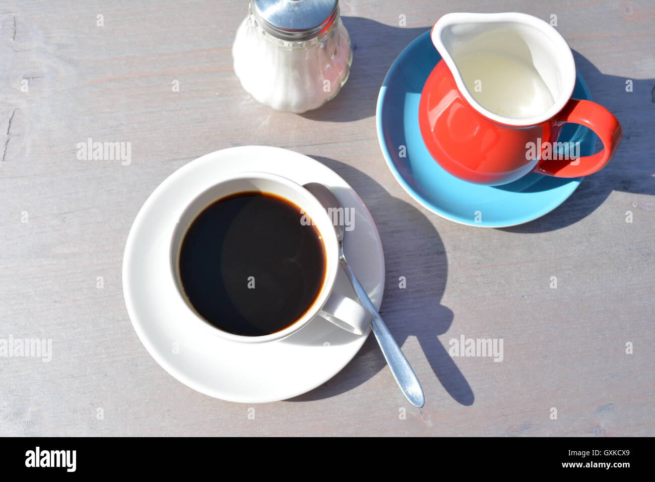 eine Tasse Kaffee mit Milch und Zucker auf einem Tisch Stockfoto