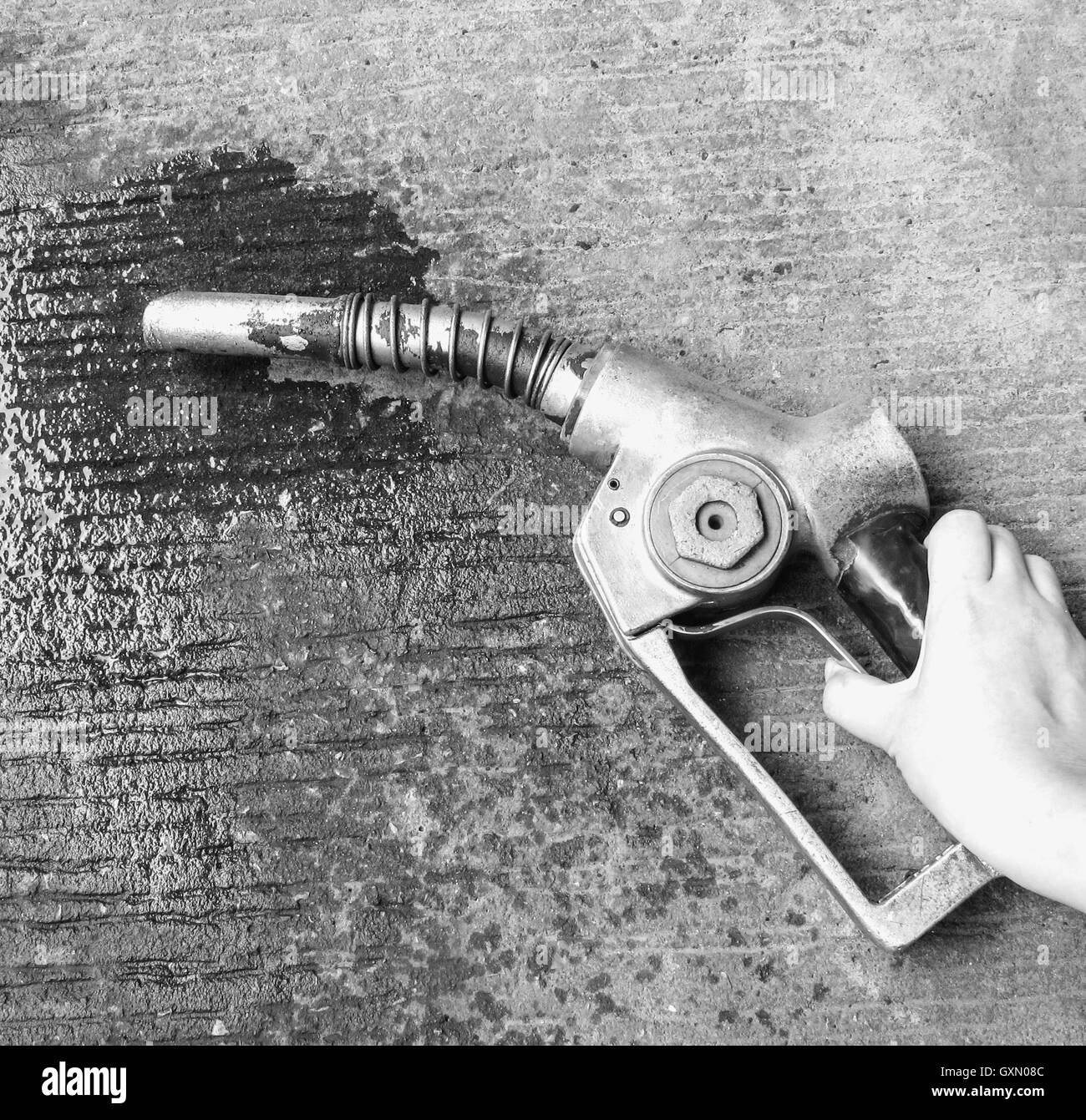 Hand, die alte Zapfsäule, Öl auf dem Boden zu verschwenden. (Schwarz / weiß-Effekt) Stockfoto