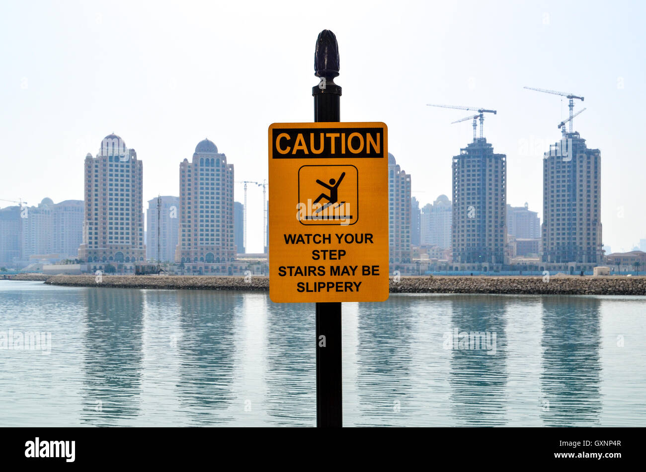 Vorsicht Zeichen in Doha, Katar, mit Kränen bauen neue Wohntürme Stockfoto