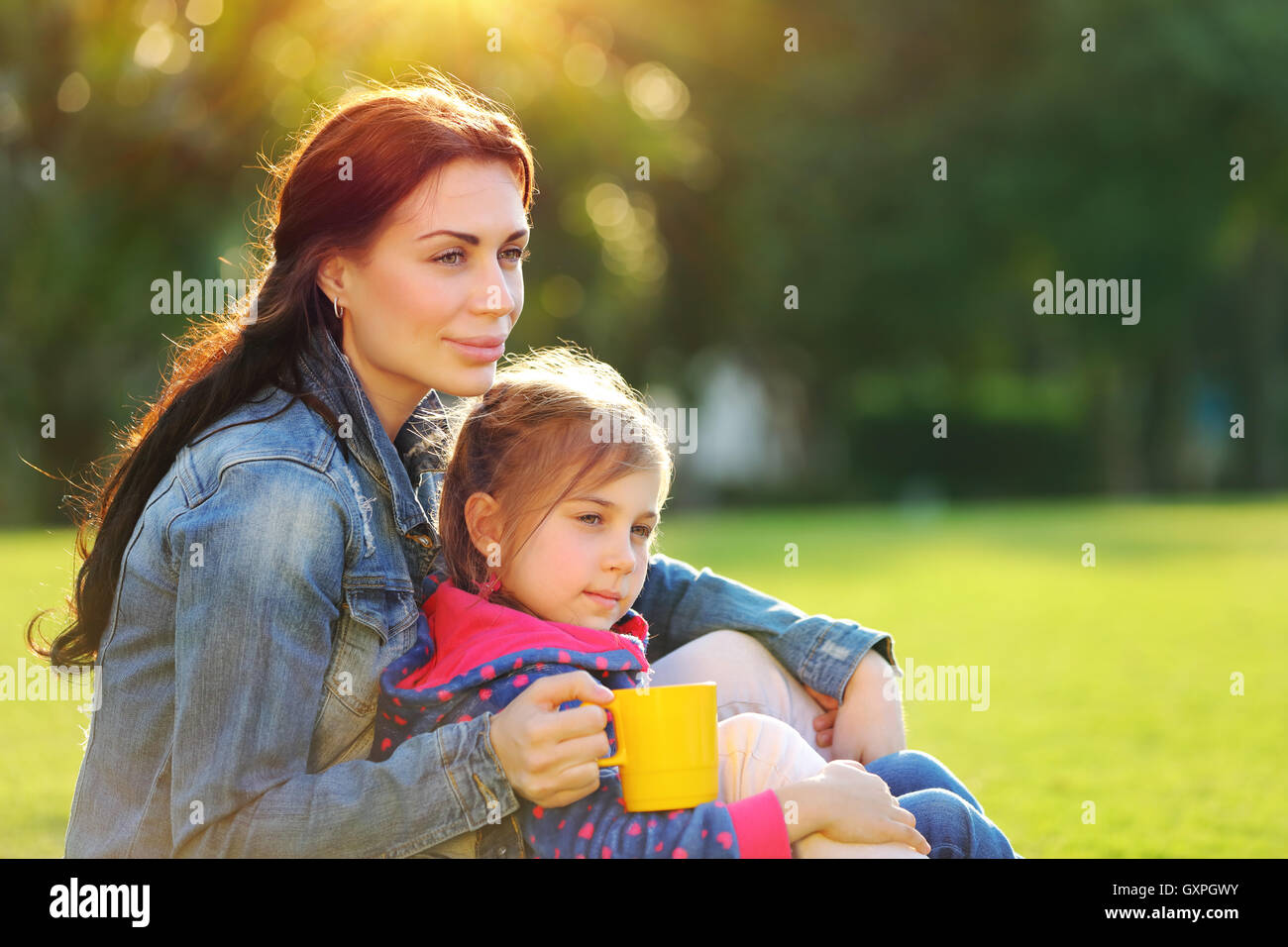 Porträt einer schönen jungen Mutter mit niedlichen kleinen Tochter im Freien entspannen, trinken Tee am Morgen Stockfoto