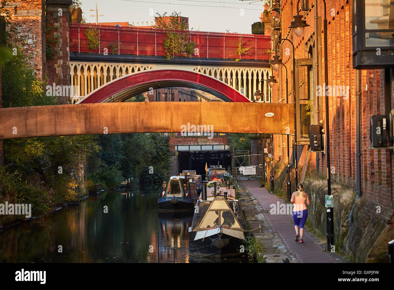 Manchester-Sperre 92 Kanalschleusen Castlefield Kanal Boote Jogger laufen Leinpfad städtische Szene golden Sunshine Eisenbahnbrücke Stockfoto