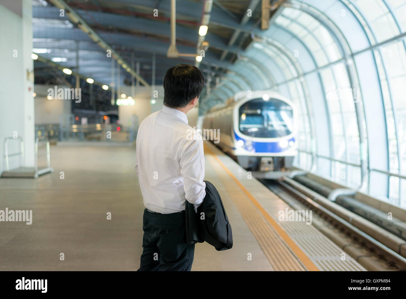 Asiatische junge Geschäftsmann u-Bahn-Zug am Bahnhof warten. Business Travel-Konzept. Stockfoto