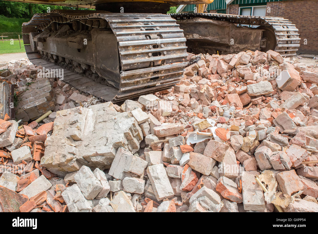 Metall Raupen auf Haufen von Ziegelbruch abgerissenen Hauses Stockfoto