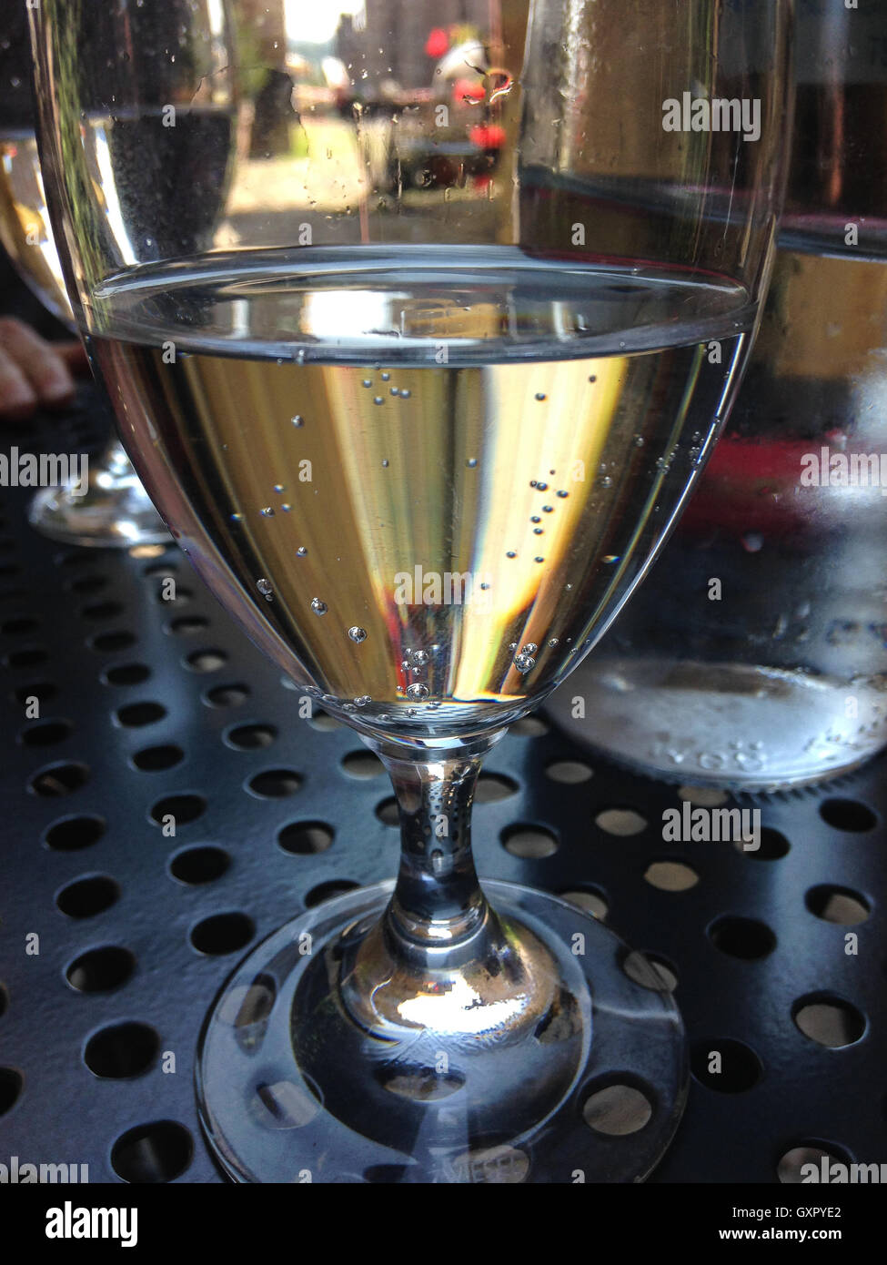 Glas mit Mineralwasser auf Metall-Tisch. Im Freien sitzen. Stockfoto