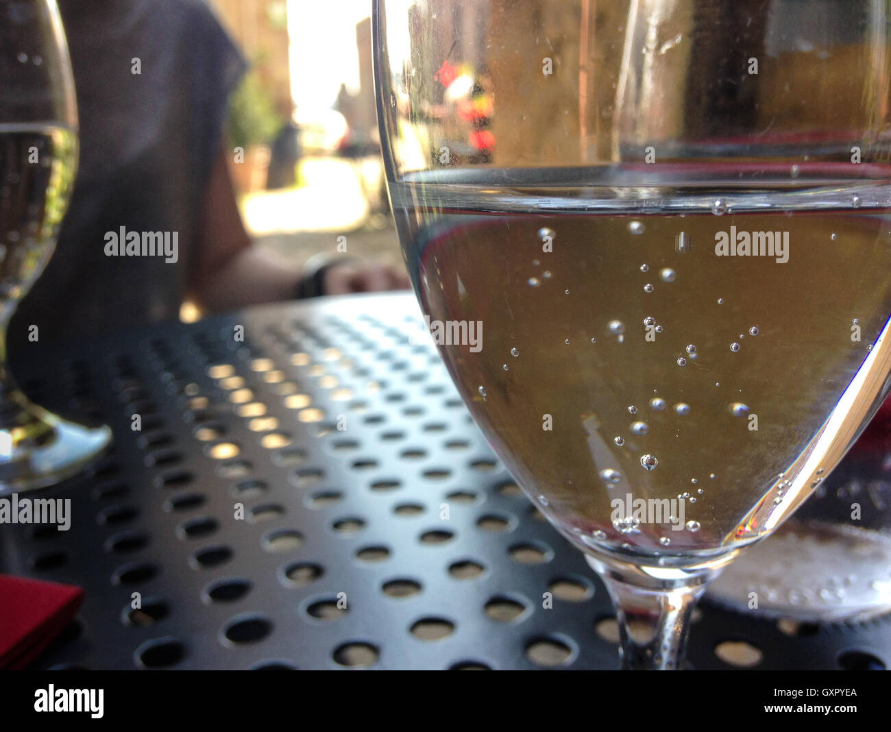 Glas mit Mineralwasser auf Metall-Tisch. Im Freien sitzen. Stockfoto