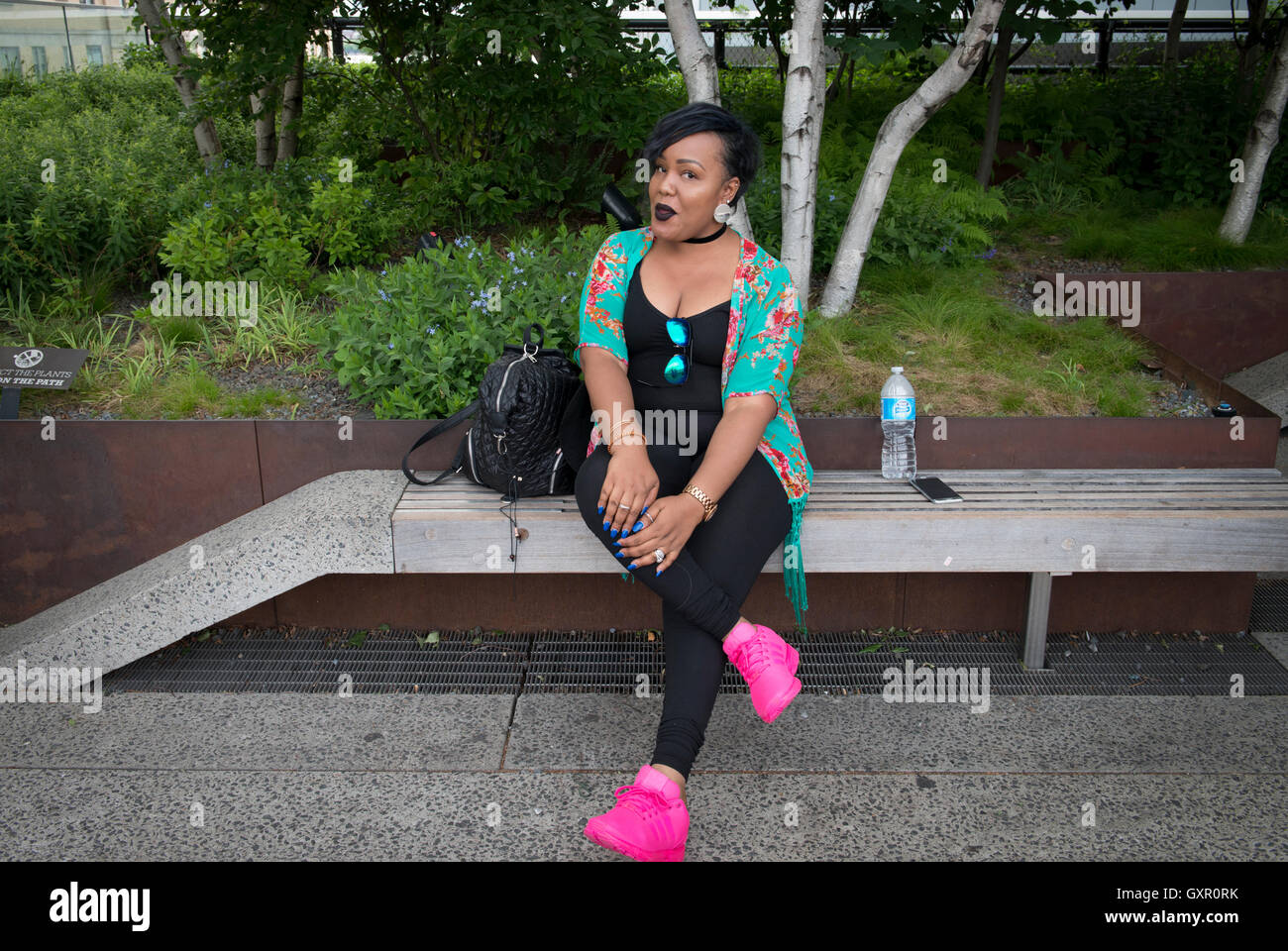Frau sitzt auf High Line, Manhattan, New York Stockfoto