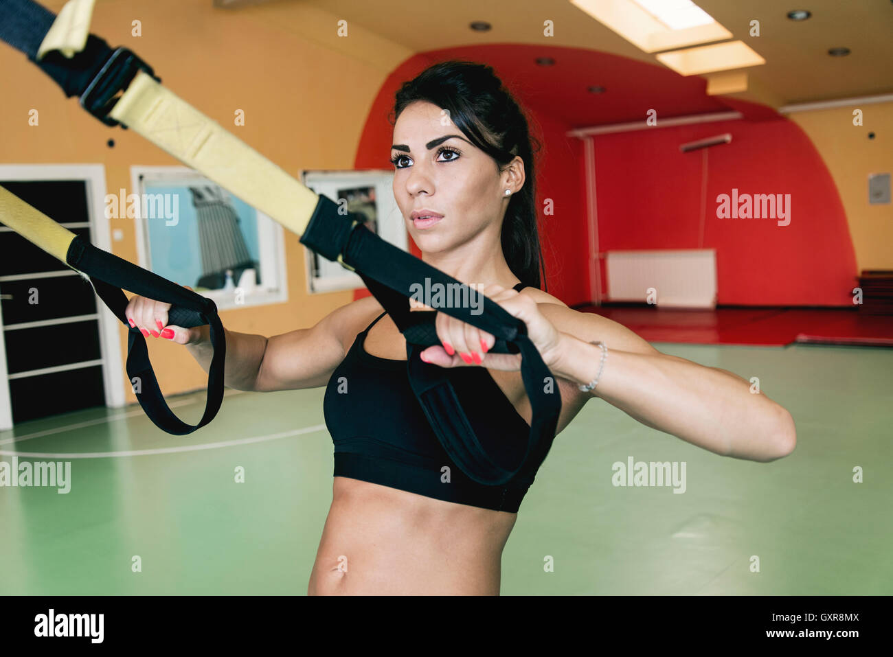 Frauen tun Push ups Training Arme mit Fitness-Trägern in der Turnhalle Stockfoto