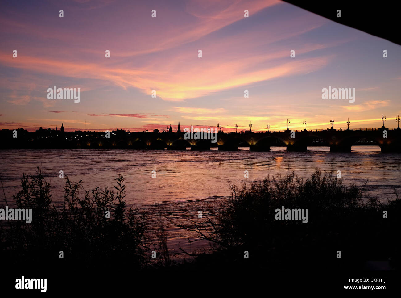 Pont de Pierre Bordeaux über Fluss Garonne bei Sonnenuntergang mit Menschen Essen im Cafe du Port Stockfoto