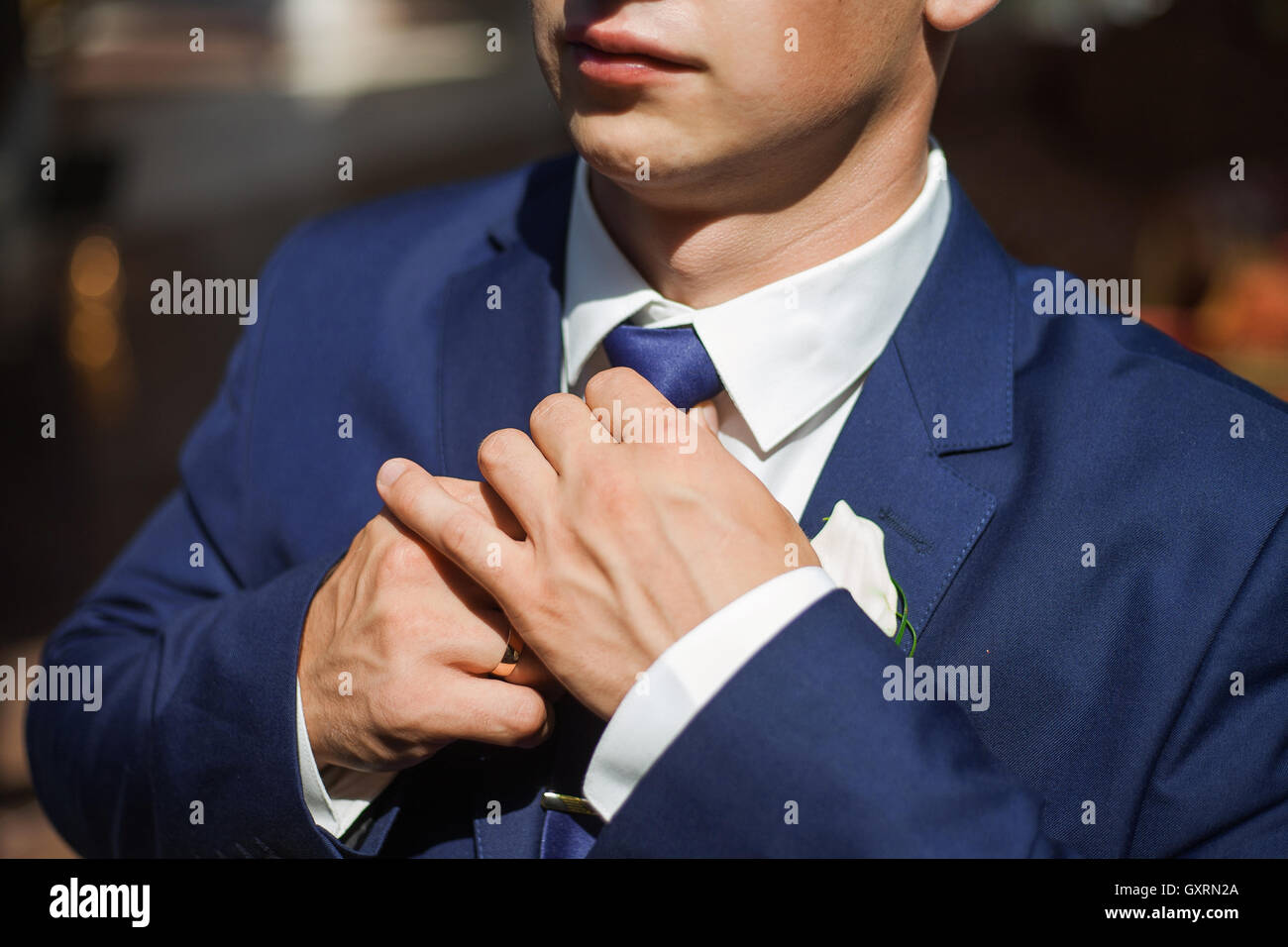 Bräutigam in einem blauen Anzug passt seine Krawatte Stockfoto