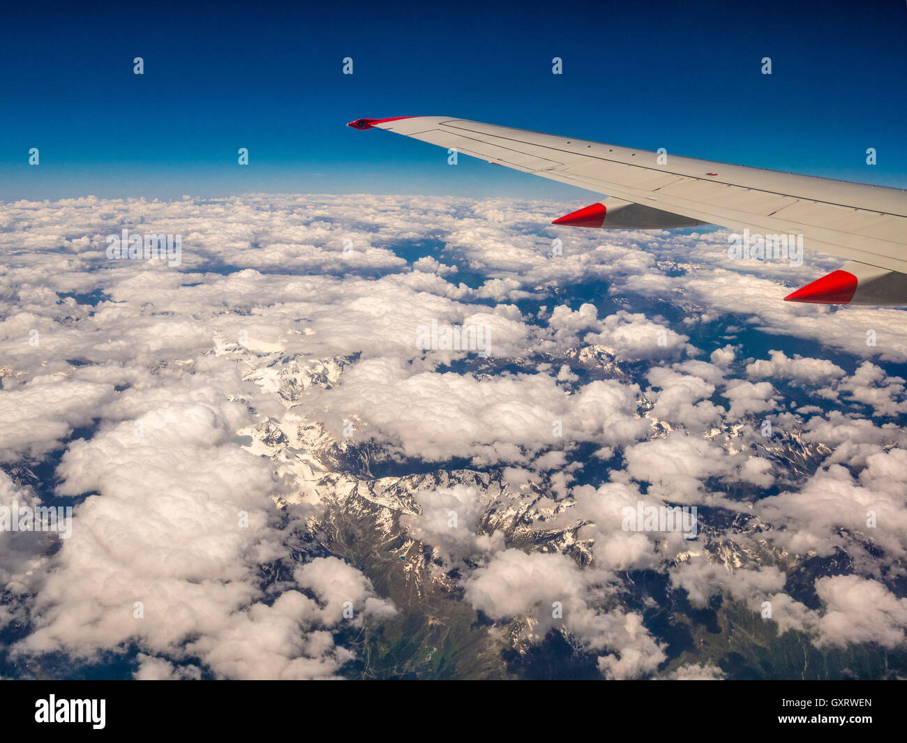 Blick durchs Flugzeugfenster über Alpen Stockfoto