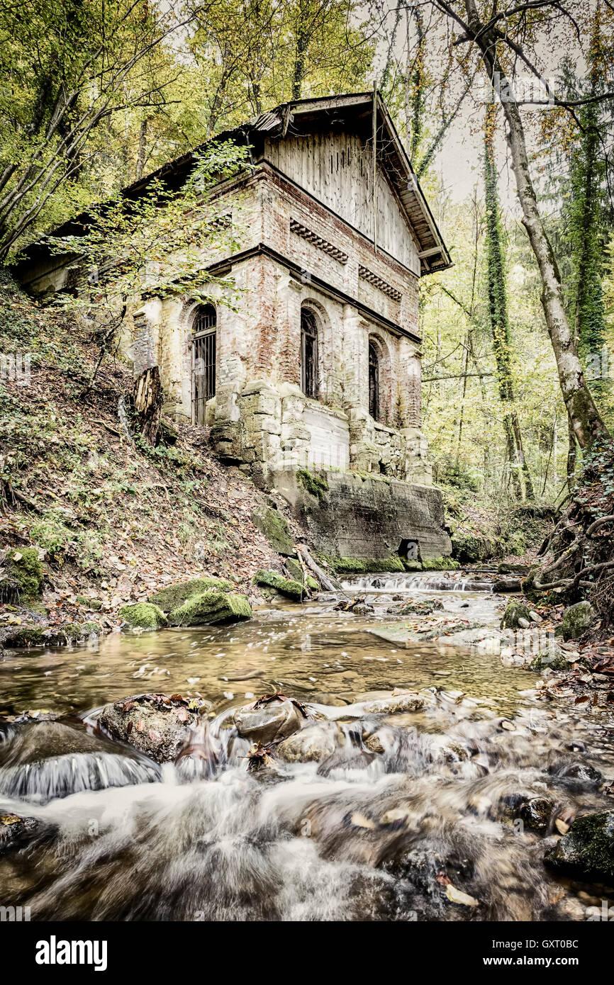 Bach im Wald mit alten Haus Stockfoto