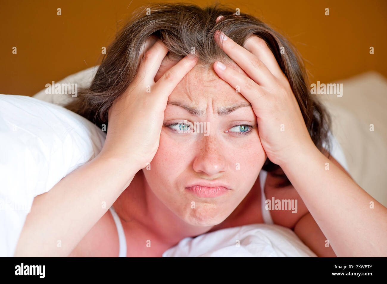 schönes Mädchen ist am Morgen im Bett in einer schlechten Stimmung aufgewacht Stockfoto