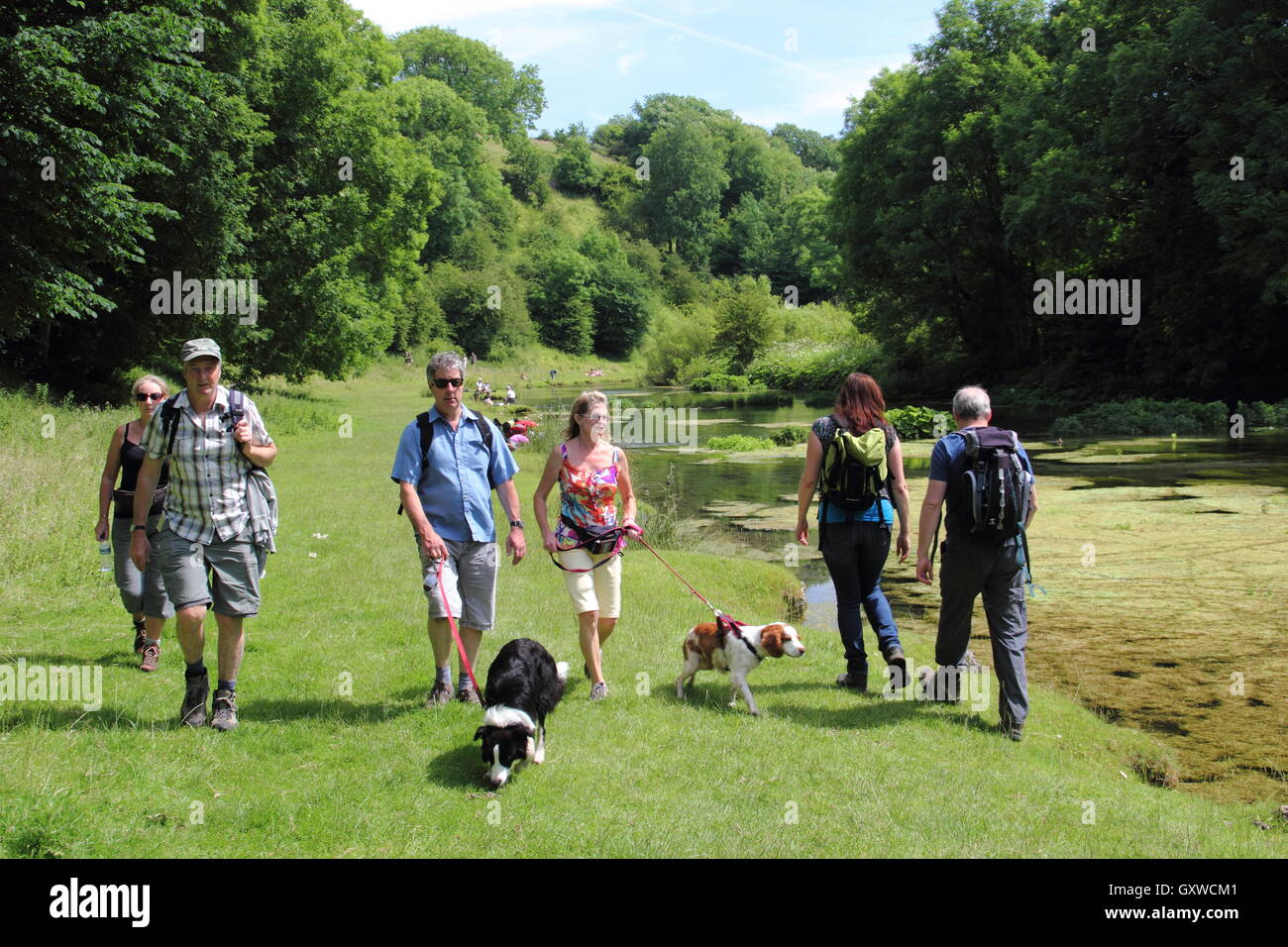 Wanderer auf eine beliebte am Flussufer Route in Lathkiill Dale, einem berühmten Kalkstein-Tal im Peak District, Derbyshire England UK Stockfoto